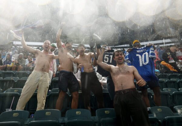 Como os torcedores passaram o primeiro atraso devido à chuva da Copa do Mundo: pegando futebol, revendendo sacos de lixo e dançando